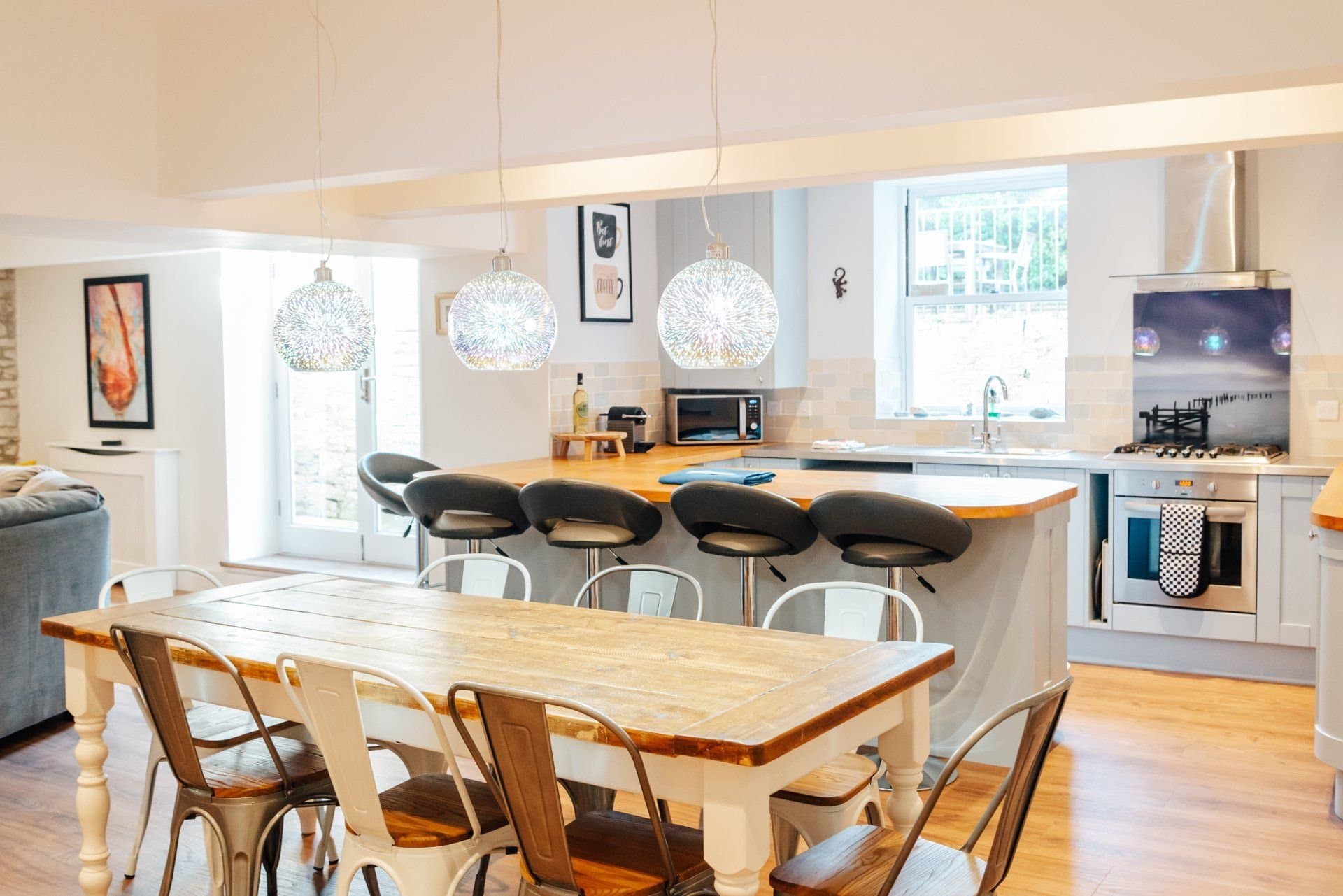 Wide view of the open-plan downstairs with dining table, breakfast bar and sofa