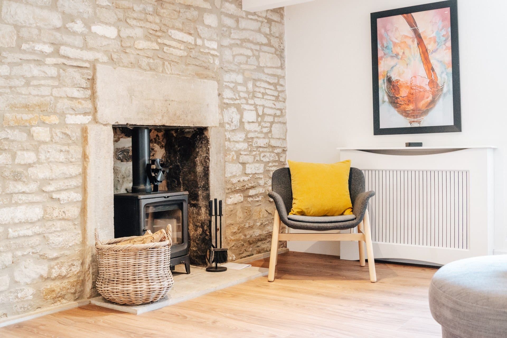 Armchair beside the log burner in the exposed stone fireplace