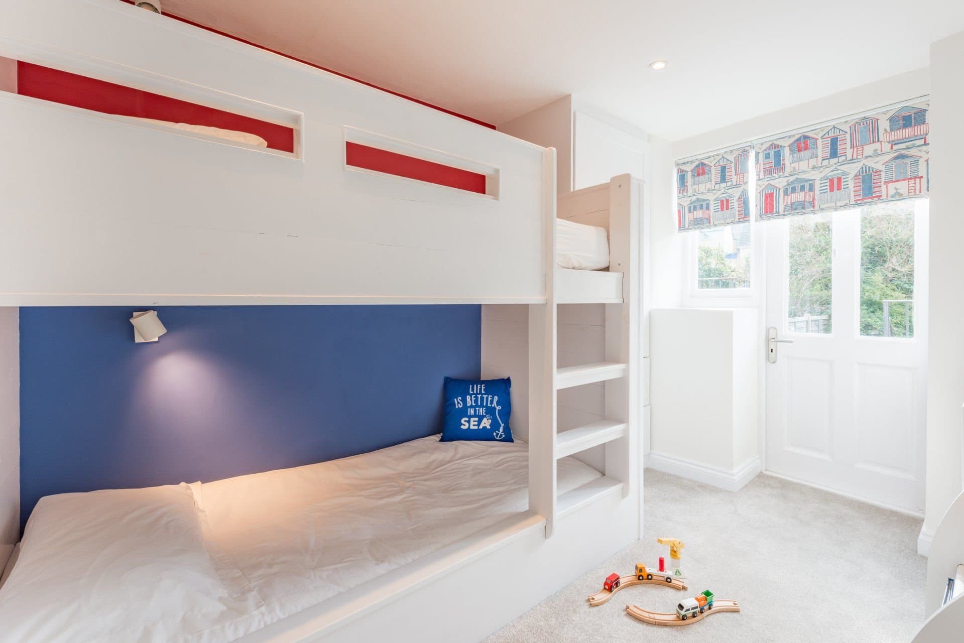 Bunk bedroom with white bunks and a seaside theme